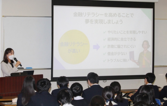 佐藤さん(左)の話に耳を傾ける生徒たち=四日市市萱生町の暁中・高で