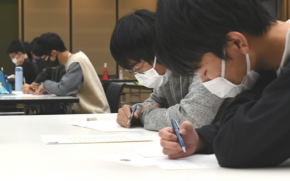 集中して筆記問題を解く参加者=岐阜市の十六銀行本店で