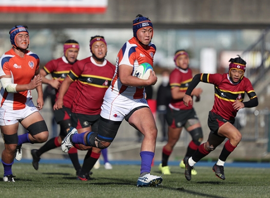 中部大春日丘－名護　前半２３分、パスを受けてトライに持ち込む中部大春日丘の選手（中央）＝花園ラグビー場で