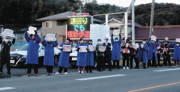 県道沿いに立ち交通安全を呼びかけるラグビー部員ら=春日井市松本町で