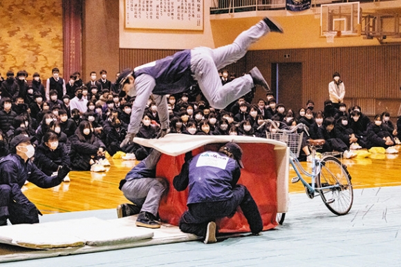 衝突事故で自転車から投げ出される様子を再現するスタントマンら=扶桑町斎藤の誠信高で