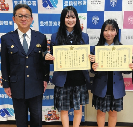 鈴木署長(左)から感謝状を受け取った2人の生徒=豊橋市の桜丘高で