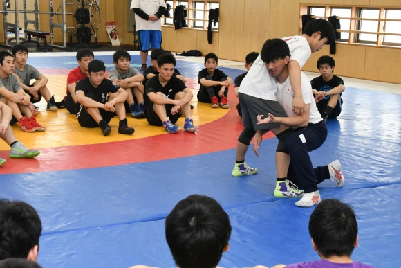 タックルに入った時の体の使い方を熱心に指導する前田さん(右側)=昭和区の名古屋工業高体育館で