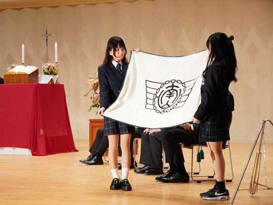 閉校式で旗ざおから取り外された校旗=豊田市亀首町の南山国際中学・高校で