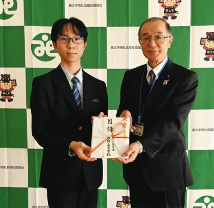 近藤会長(右)に目録を手渡す生徒会長の生徒=長久手市前熊下田の市福祉の家で