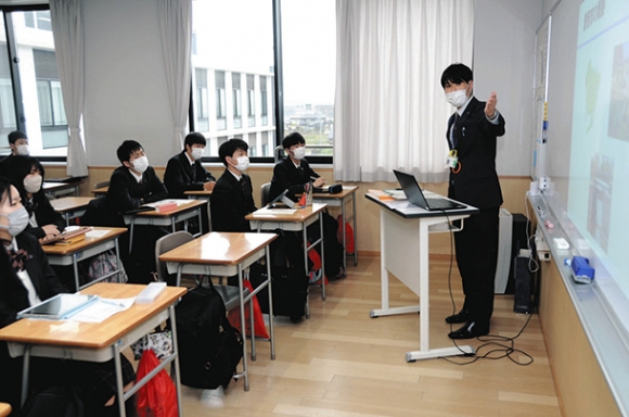 生徒に市の課題について説明する市職員(右)=愛西市の清林館高で