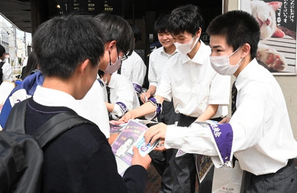 高校生らに「闇バイトに加担しないで」と呼びかけながらチラシを配る愛工大名電高の生徒ら=名古屋市千種区で
