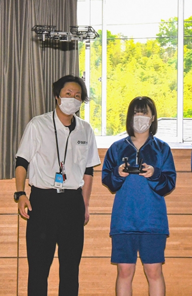 ドローンの操縦を体験する生徒(右)=名張市桔梗が丘1の英心高桔梗が丘校で