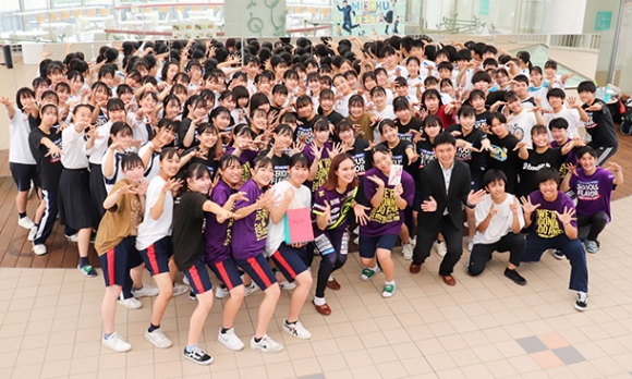 三重高ダンス部に寄付金を贈った竹上社長（最前列右から３人目）と林選手（同５人目）＝松阪市久保町の三重高で