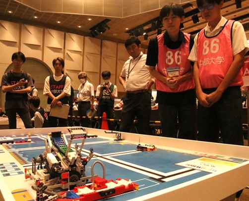 自動で動くロボットを見守る生徒ら=春日井市松本町の中部大で