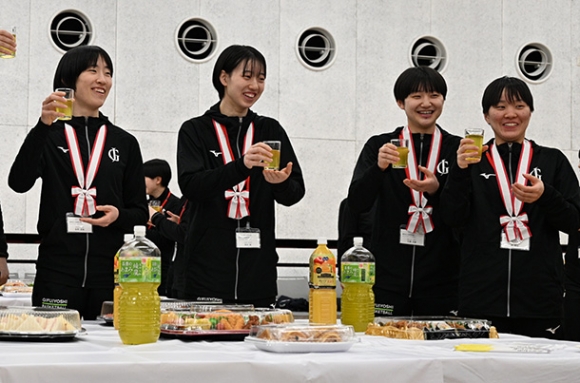 乾杯でグラスを掲げる主将（左）たち＝岐南町八剣の中央公民館で