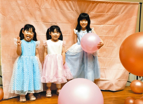 多治見西高被服科の生徒が作ったドレスを着る来場者＝多治見市十九田町２のバロー文化ホールで