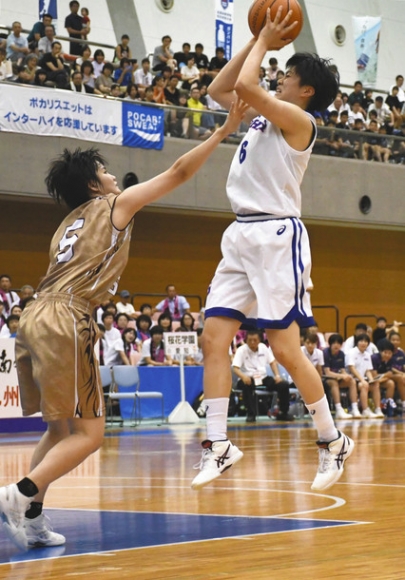 第２クオーター、相手のディフェンスをかわしてシュートを放つ岡本選手（右）＝鹿児島県薩摩川内市で