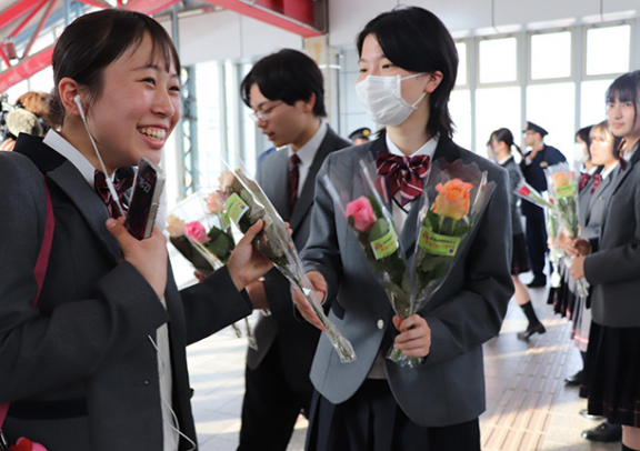 「とよかわバラ」を駅利用者に手渡し、「痴漢・盗撮被害からまも“ローズ”」と呼びかけた豊川高生ら＝豊川市のＪＲ豊川駅で