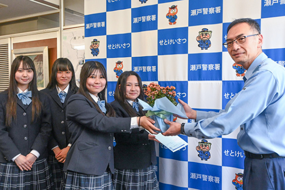 鉢花を井上署長に手渡す生徒たち＝瀬戸市原山町の瀬戸署で