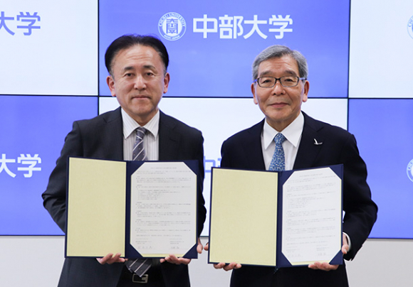 協定書を交わした生駒校長（左）と前島学長＝愛知県春日井市の中部大で