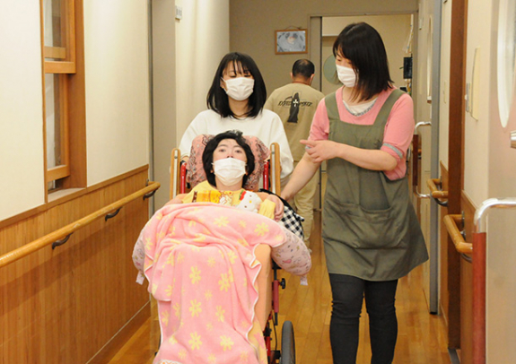 スタッフに教わりながら車いすを押す生徒＝新城市矢部で