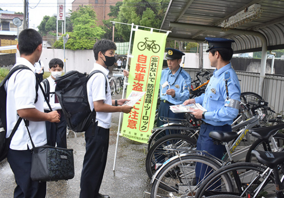 駐輪場で生徒たちにツーロックの徹底を呼びかける署員＝豊明市の星城高で