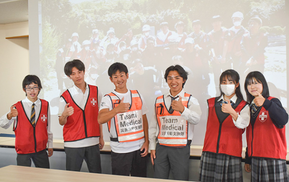 親指で能登半島を表現する生徒ら。多くの人の被災地支援を呼びかけている＝千種区の愛知高で