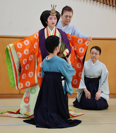 十二単の着付けを体験する生徒＝豊橋市老松町の藤ノ花女子高で