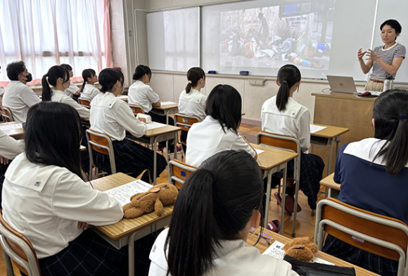 路上生活するフィリピンの子どもの過酷な日常を紹介しつつ、自らの活動を説明する吉田さん（右端）＝岐阜市の富田高で