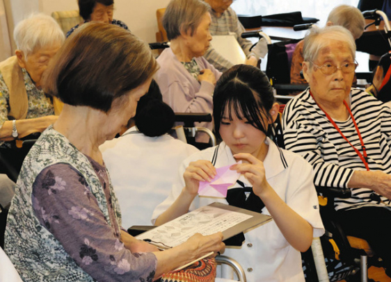 平和への願いを書いた折り鶴を作る高校生とお年寄り＝天白区のリハビリホームボンセジュール植田で