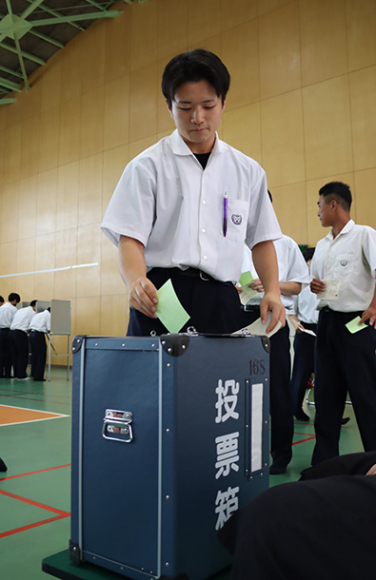 練習用の投票用紙に記入し、模擬選挙を体験する生徒＝豊橋市鍵田町の豊橋中央高で