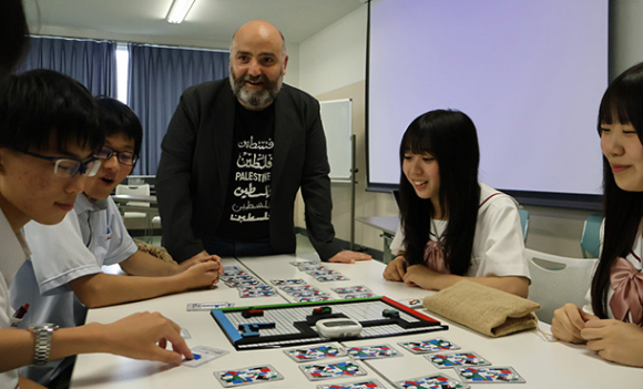 アハマドさん（左から３人目）が考案したパレスチナとイスラエルの関係性がわかるボードゲームをプレーする生徒ら＝名古屋市千種区の名経大市邨高で