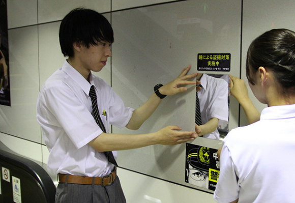 防犯ミラーを取り付ける生徒たち＝市営地下鉄金山駅で