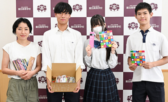 集まった文房具を手にする生徒ら＝岐阜市野一色の富田高で