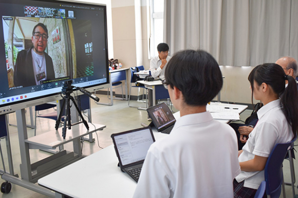 カンボジアからの生中継（画面）で虐殺の歴史を学ぶ生徒たち＝千種区の名経大市邨高で