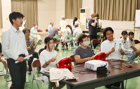 高校生に教わりながらゲームを楽しむ参加者ら=瑞浪市稲津町小里の稲津公民館で