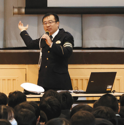 生徒に交通ルール順守を呼びかけた一宮署の永谷警部補＝一宮市日光町の修文学院高で