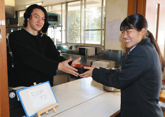 まぜそばを手渡す通信制の生徒(左)ら=四日市市の四日市メリノール学院高で