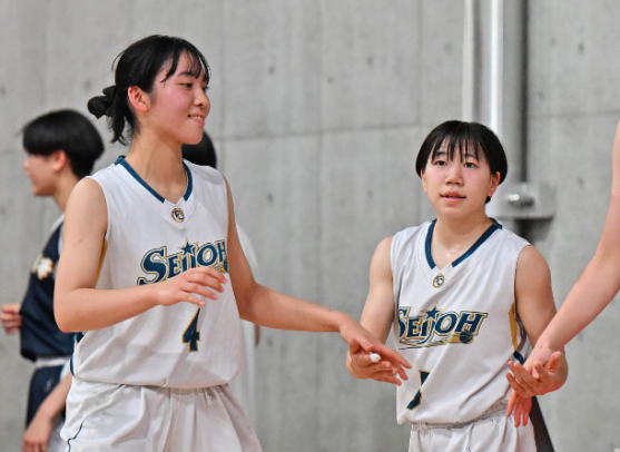 星城－京都精華学園　第２クオーターのタイム中、試合再開の前に手を重ね合わせる星城の荻野主将（左）と小林選手