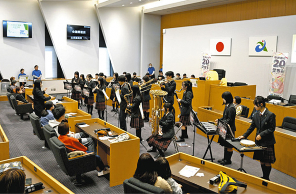 議場の真ん中で演奏する清林館中・高の吹奏楽部=愛西市議会で