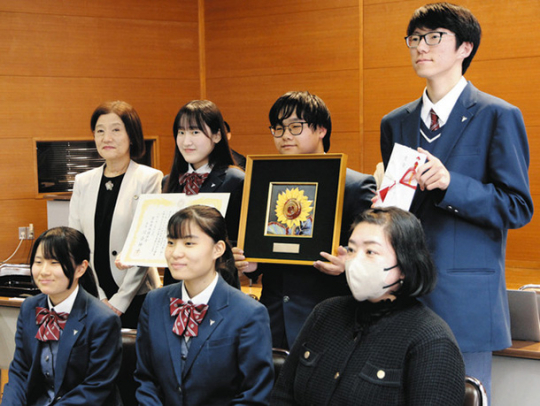県弁護士会の人権賞に選ばれ、表彰状と記念品のひまわりのレリーフを受け取る東邦高の生徒ら＝名古屋市中区の県弁護士会館で