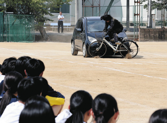 自転車事故の怖さを体感する生徒たち＝多治見市明和町の多治見西高で