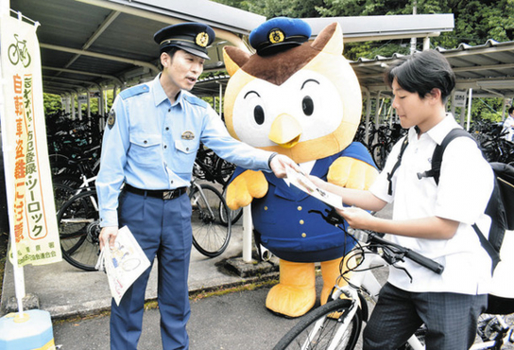ツーロックの徹底を呼びかける署員(左)とコノハけいぶ(中)=日進市三本木町の中部大第一高で