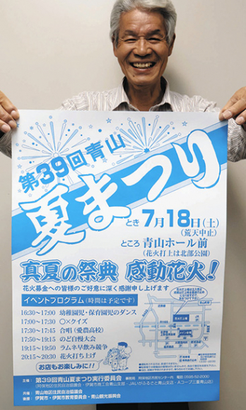 ポスターを掲げて来場を呼びかける稲森さん＝伊賀市阿保の阿保地区市民センターで