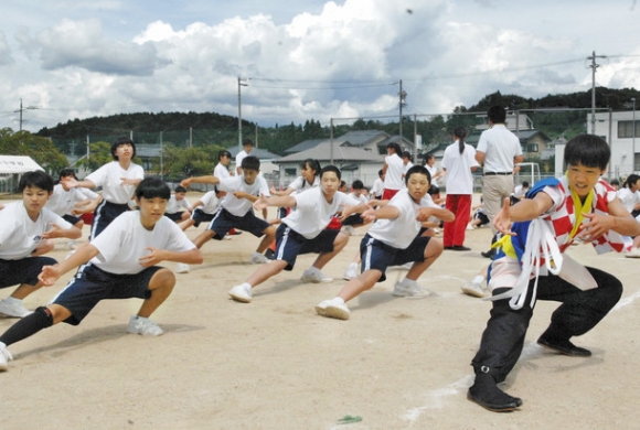 中京院中京高の生徒（右）から踊りの基本動作を学ぶ恵那東中２年生ら＝恵那市の同中で
