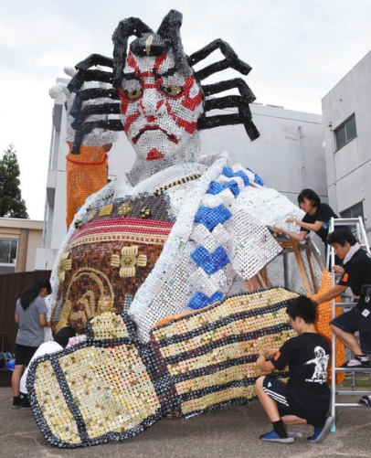 ペットボトルのキャップを使った巨大作品を制作する生徒たち=愛知県岡崎市の岡崎城西高で