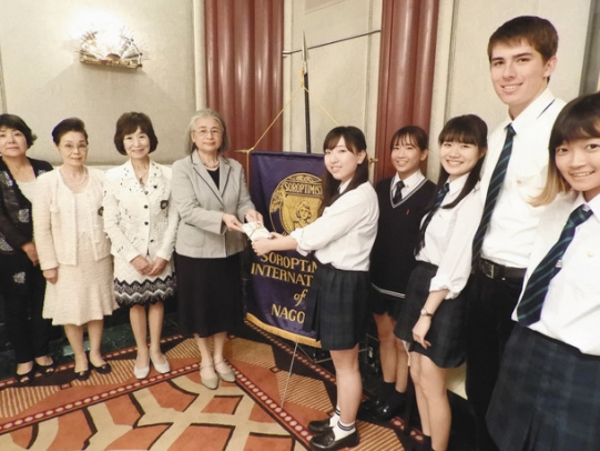 八代会長(左から4人目)から育成助成金を受け取る生徒ら=中区のホテルで