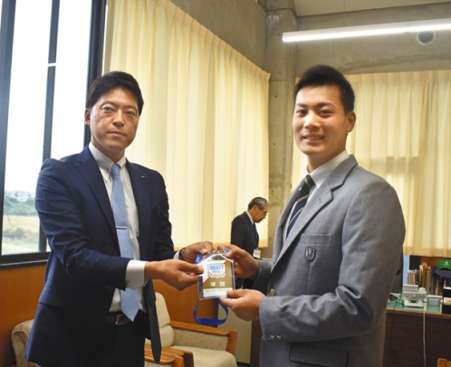 オリックスの谷口スカウト（左）から指名あいさつを受けた前投手＝桑名市野田の津田学園高で