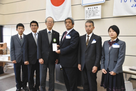 豊川高駅伝部に激励金を贈る豊川ＲＣの川合会長（左から３人目）＝豊川市の豊川商工会議所で