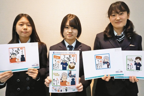 ニセ電話詐欺への注意を呼びかけるパズルを手にする名古屋市工芸高の生徒ら=栄の県美術館で
