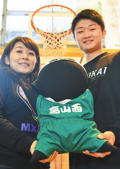 贈られたオリジナルさるぼぼを手に、笑顔を見せるＯＧの山口さん（左）と不破主将＝高山市下林町の高山西高で