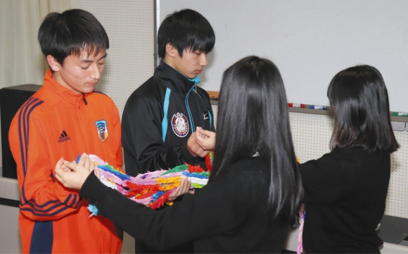 全校生徒でつくった千羽鶴を受け取る選手代表（左）＝瑞浪市土岐町の中京院中京高で