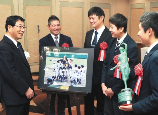 高校軟式野球全国選手権大会で３連覇を果たした瞬間の写真パネルを囲み談笑する（左から）古田知事、中京院中京軟式野球部の平中監督、佐藤部長、水投手、村瀬前主将＝岐阜市の岐阜グランドホテルで