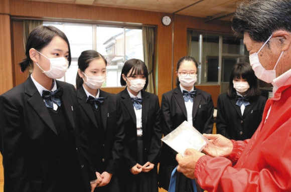 地元高齢者らのために作ったマスクを庄野地区まちづくり協議会に託した生徒たち=鈴鹿市庄野町の庄野地区市民センターで